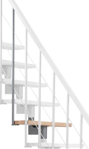 A toddler plays with colorful toys on the floor in front of the mounted "Annika" wooden child safety gate. The gate is installed between two walls, separating the play area from the kitchen behind.