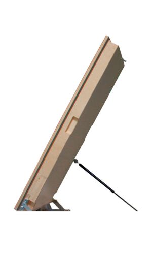 A toddler plays with colorful toys on the floor in front of the mounted "Annika" wooden child safety gate. The gate is installed between two walls, separating the play area from the kitchen behind.