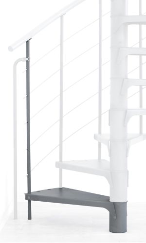 A toddler plays with colorful toys on the floor in front of the mounted "Annika" wooden child safety gate. The gate is installed between two walls, separating the play area from the kitchen behind.