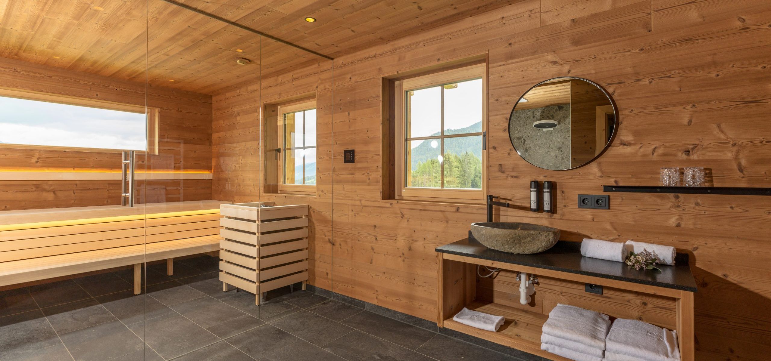 Wellness area with sauna in Almwelt Schwab-Walcher, featuring wall and ceiling cladding made of brushed Gladiola wood by Minka.