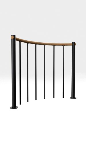 A toddler plays with colorful toys on the floor in front of the mounted "Annika" wooden child safety gate. The gate is installed between two walls, separating the play area from the kitchen behind.