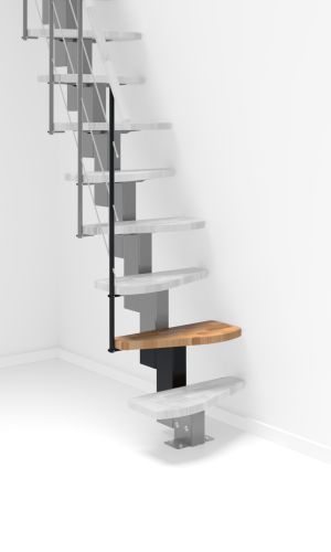 A toddler plays with colorful toys on the floor in front of the mounted "Annika" wooden child safety gate. The gate is installed between two walls, separating the play area from the kitchen behind.