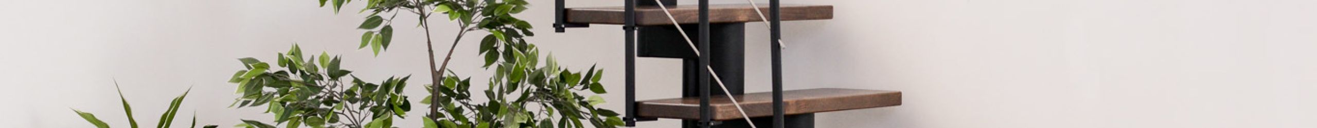 Central stringer staircase Comfort Top with walnut steps and a black metal railing with understraps and a PVC handrail.