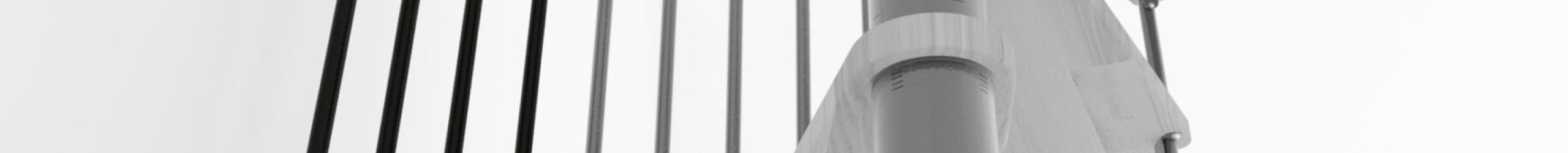 Height extension for the staircase Spiral Smart with steps in oak, black steel banister and PVC handrail. A detail of the additional step and the balusters is shown.