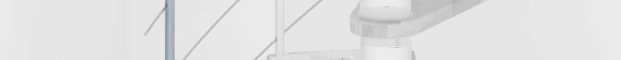 Height extension for the spiral staircase Venezia Smart with steps in beech and white metal. A detail of the additional step and the balusters is shown.