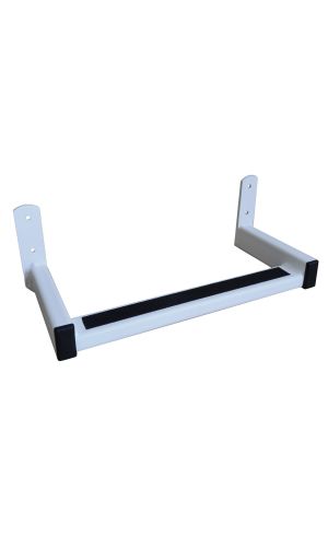 A toddler plays with colorful toys on the floor in front of the mounted "Annika" wooden child safety gate. The gate is installed between two walls, separating the play area from the kitchen behind.