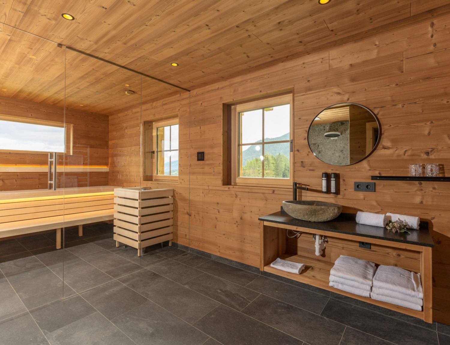 Wellness area with sauna in Almwelt Schwab-Walcher, featuring wall and ceiling cladding made of brushed Gladiola wood by Minka.