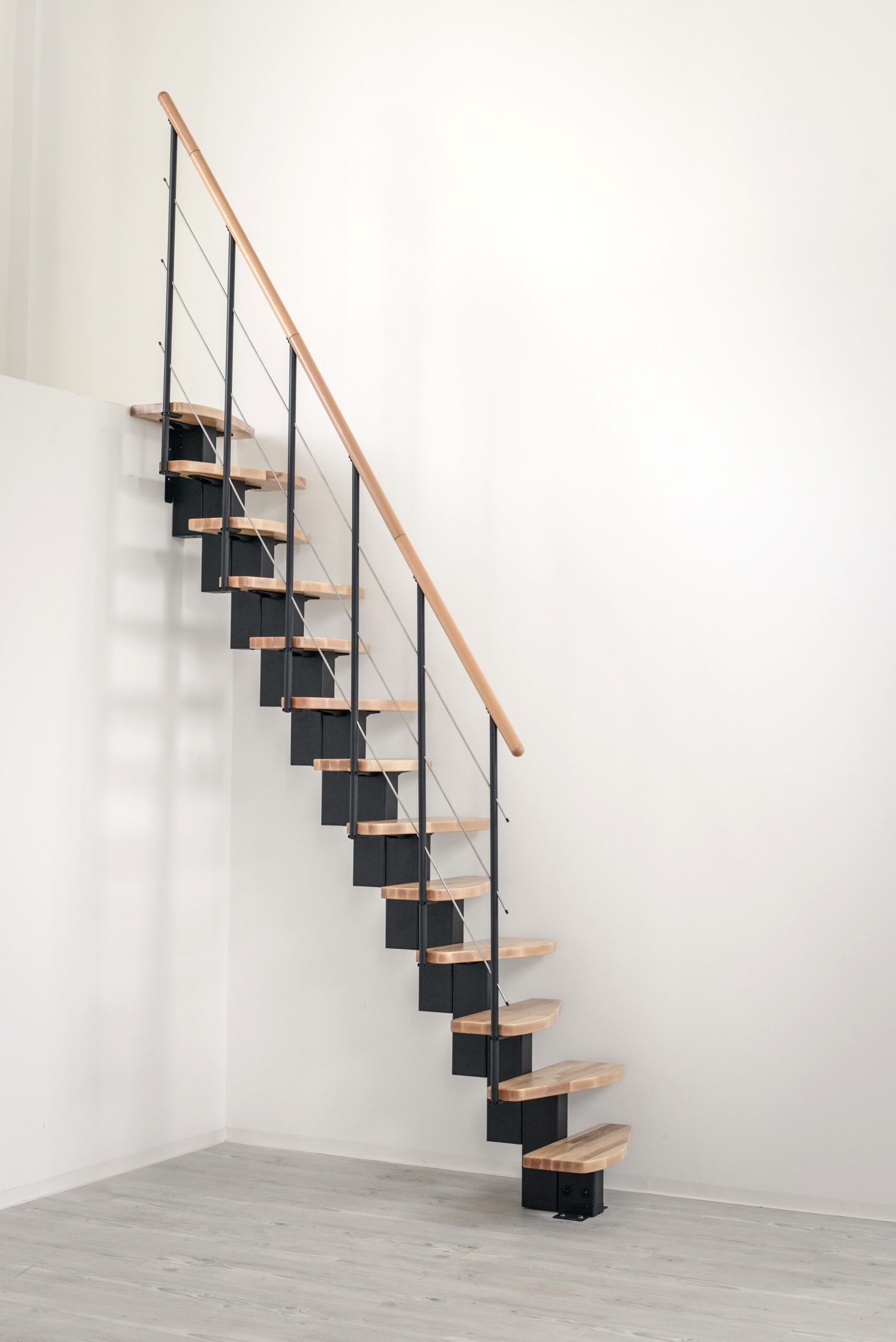 Quatro central stringer staircase with beech steps and a black metal railing with horizontal bars and a wooden handrail.