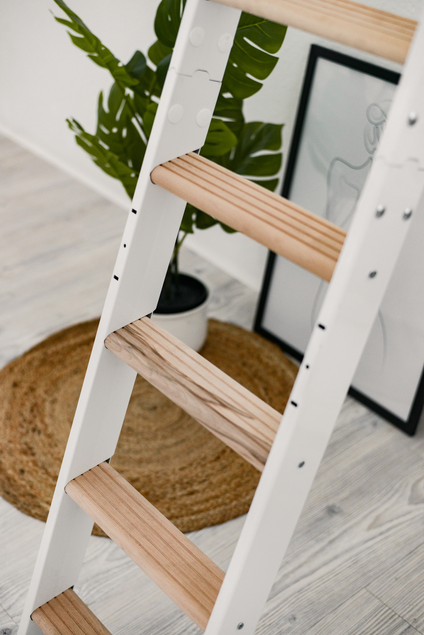 Close-up of the Strong space-saving staircase with a white frame and beech steps. The finely grooved treads and the bolted construction are clearly visible.