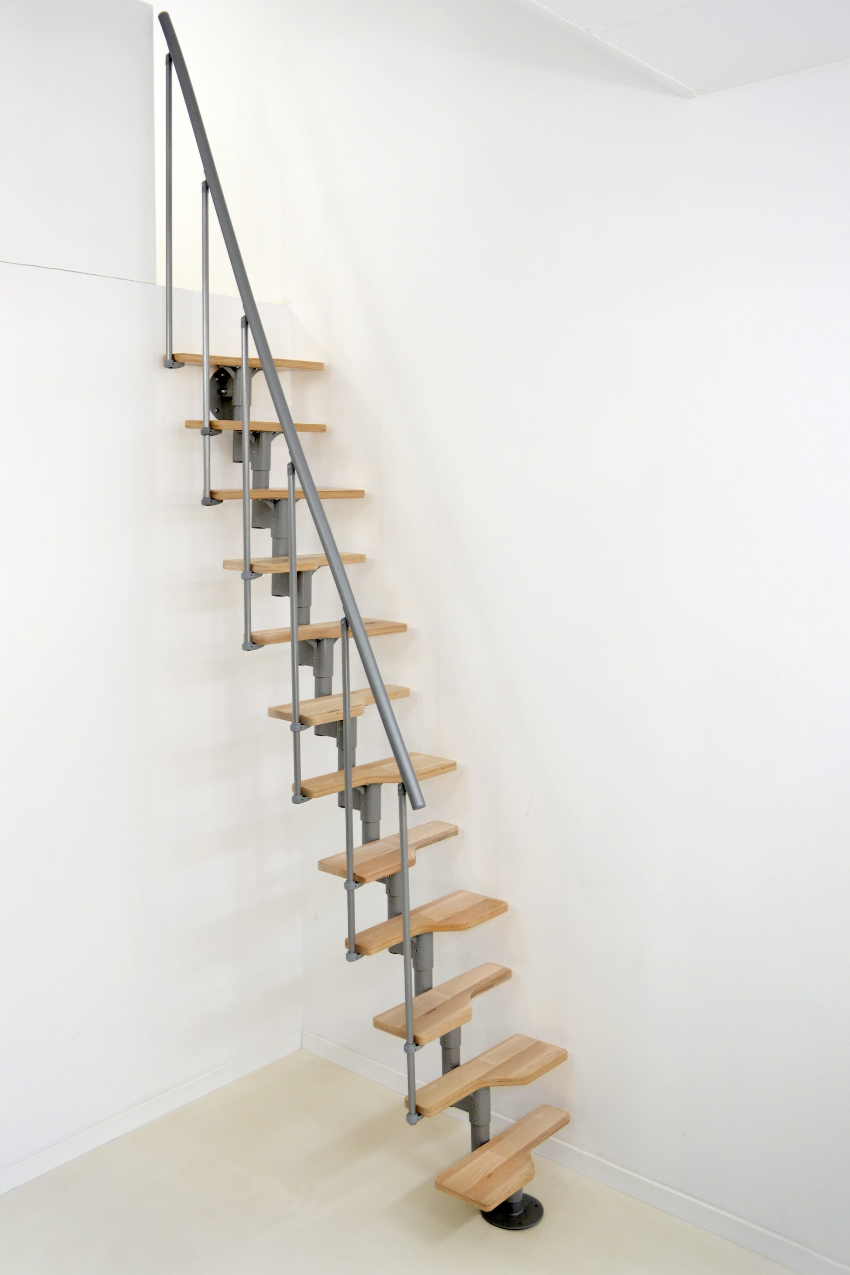 Vienna central stringer staircase with beech steps, grey metal railing, and PVC handrail.