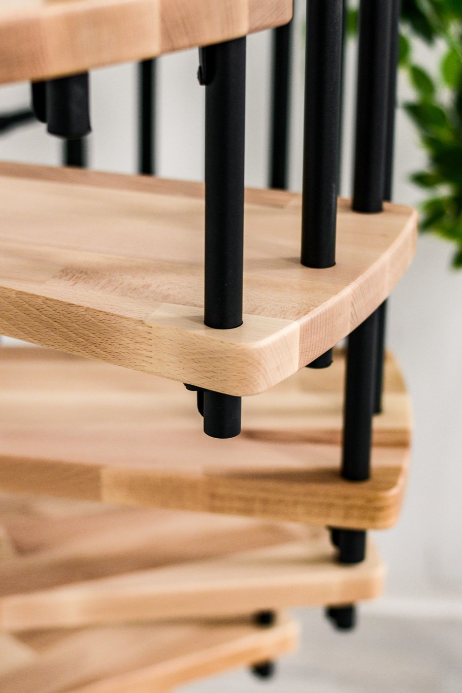 Detail of the Berlin spiral staircase with light wooden steps and black metal rods in a spiral arrangement – modern, minimalist design.