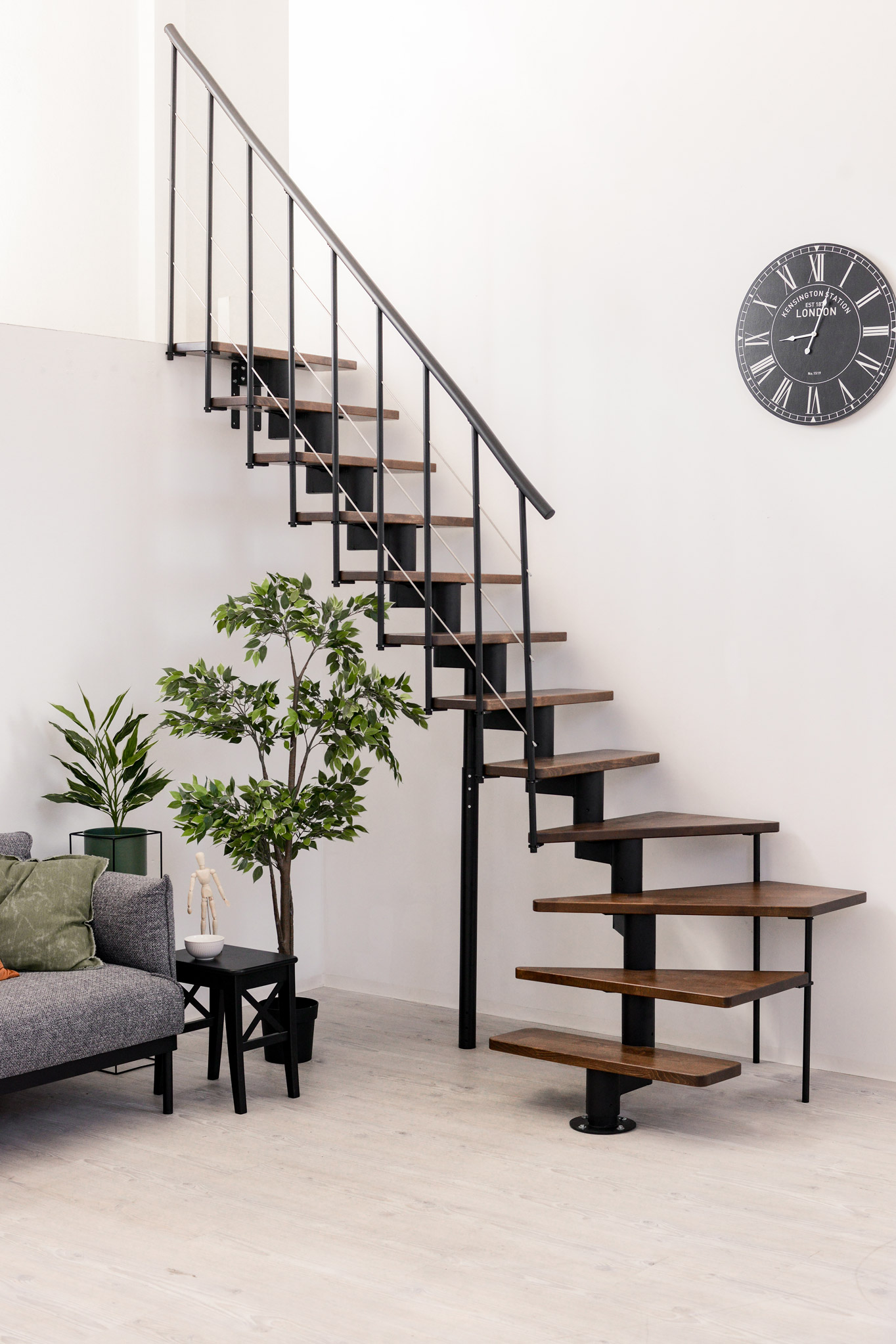 Central stringer staircase Comfort Top with walnut steps and a black metal railing with understraps and a PVC handrail.