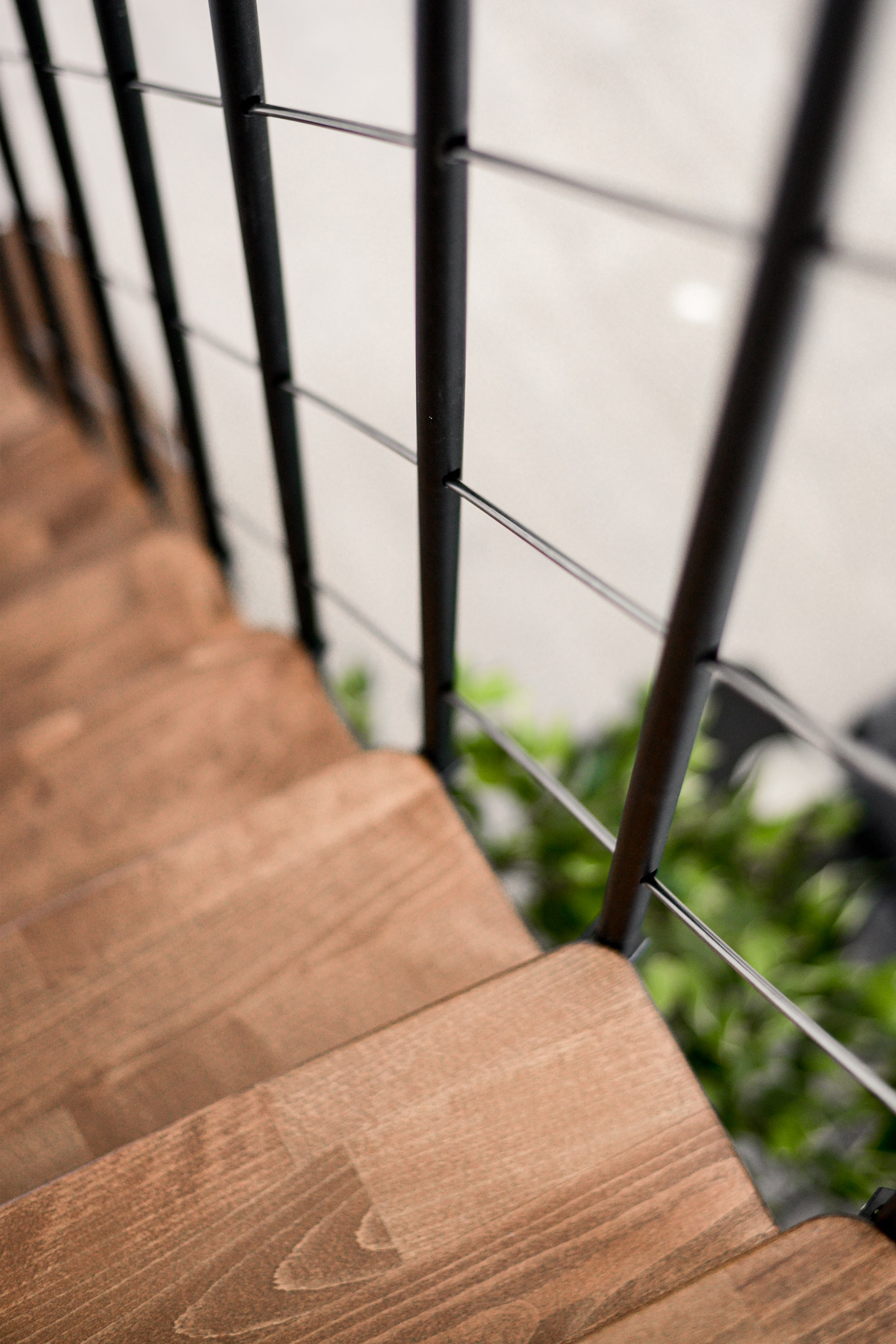 Detailed view of the Comfort Top Turn staircase in black-walnut design. The dark walnut-look wooden steps complement the modern black railing.