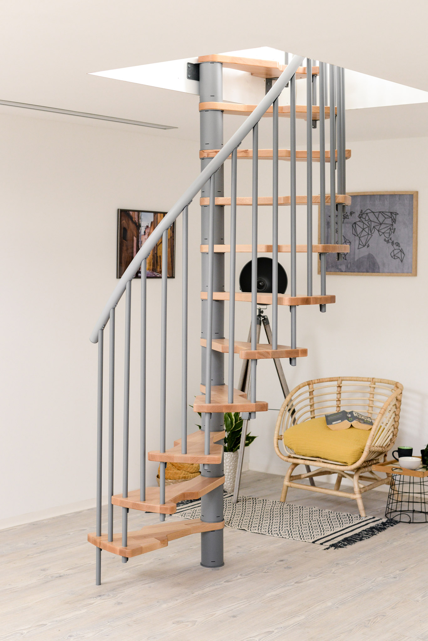 The Metallica Smart spiral staircase features a grey metal frame and light wooden steps, fitting perfectly into modern interiors. Compact design for stylish space-saving solutions.