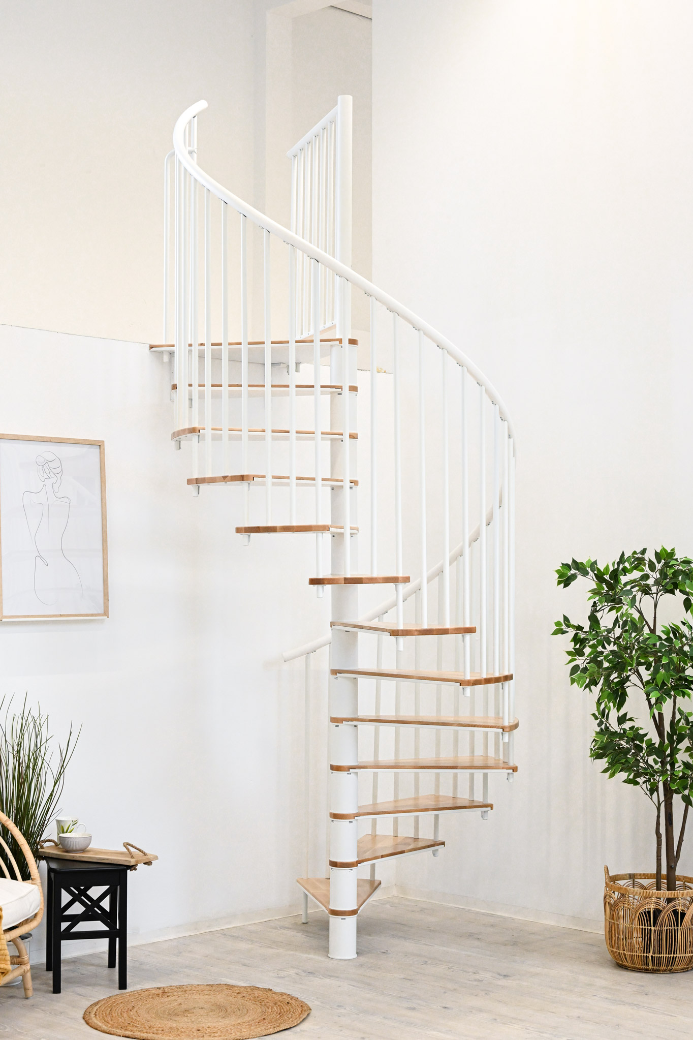 Switch spiral staircase with beech steps and white metal banister installed in a bright room with plants, chair and side table