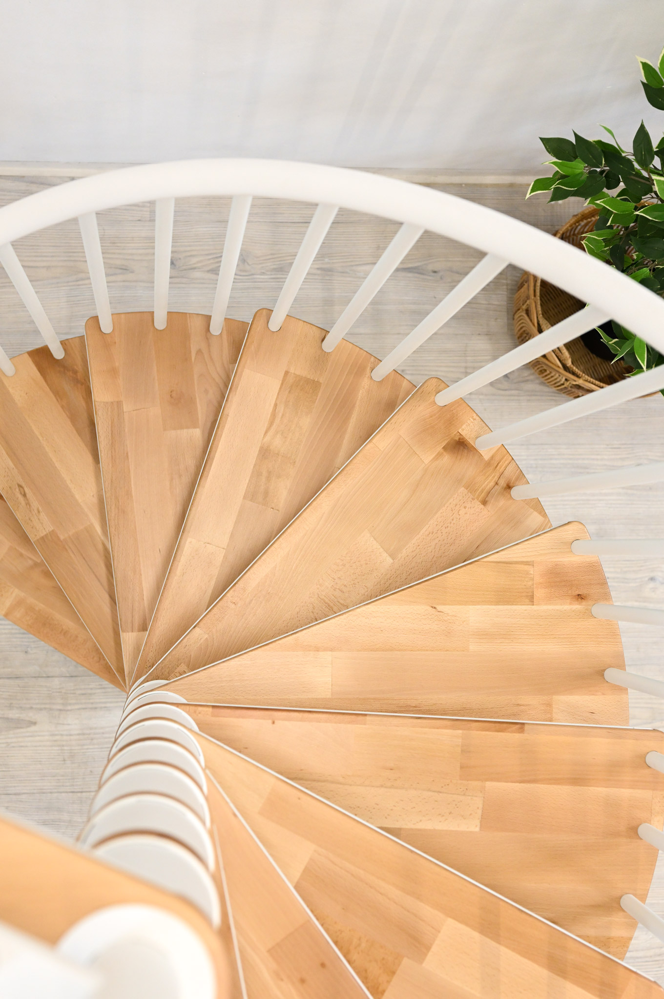 Close-up of the Switch spiral staircase, view from above of the beech steps and the white PVC handrail.