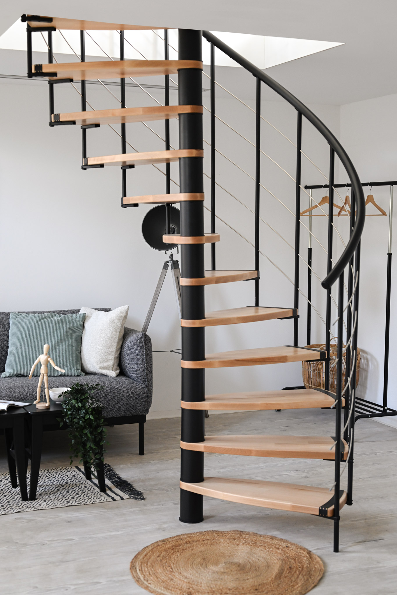 Modern spiral staircase Helios with a stylish combination of light-coloured wood and black metal - space-saving, elegant and ideal for contemporary living.
