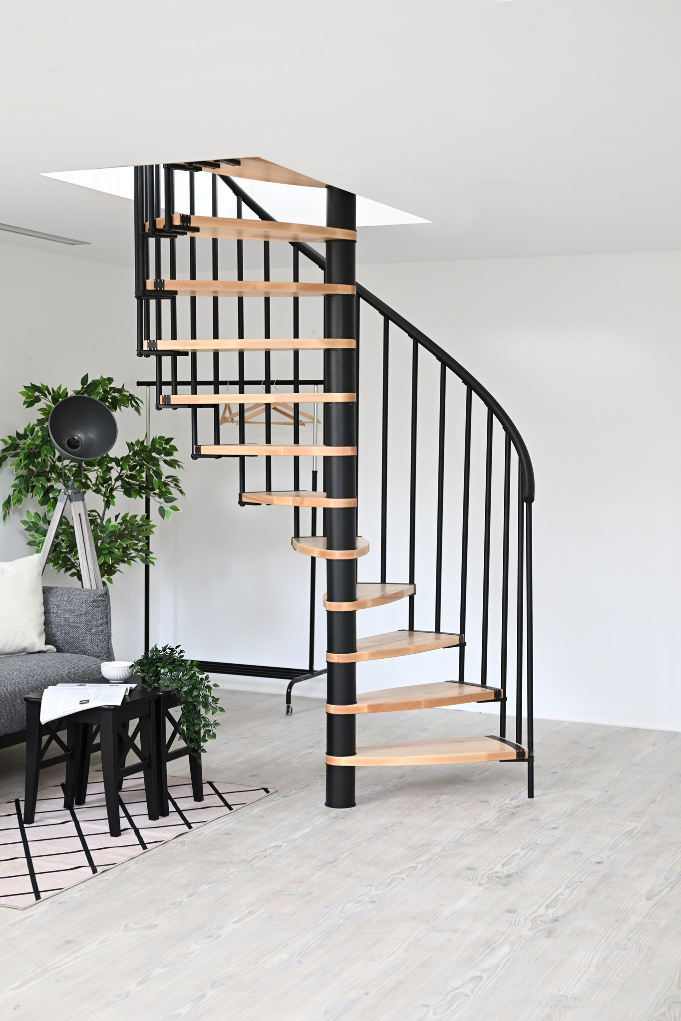 The Luna spiral staircase impresses with its modern design featuring light wooden steps and a black metal frame. Perfectly suited for stylish and space-saving living concepts.