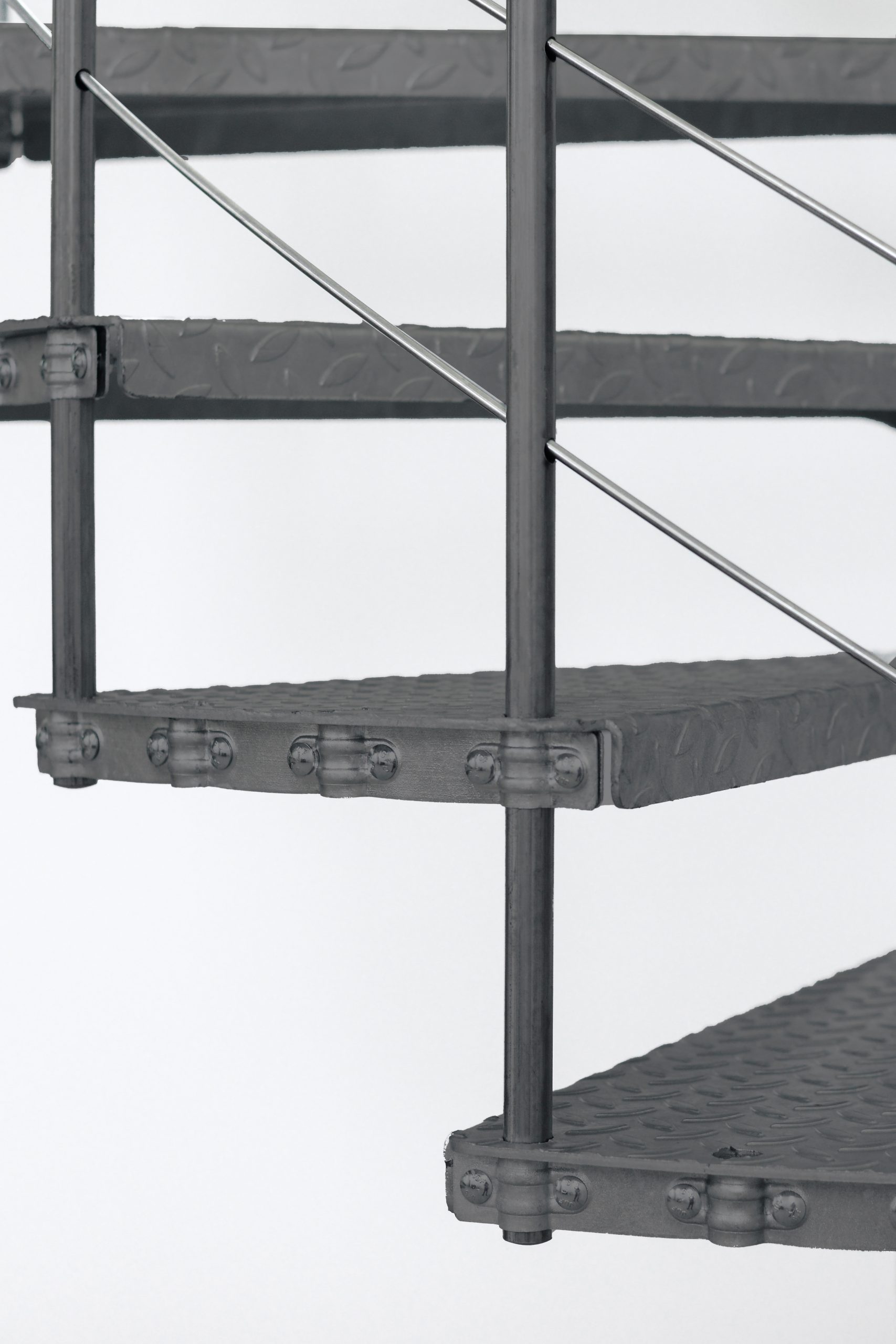 Close-up of the steps of the outdoor spiral staircase Spino Zink Color in anthracite. The non-slip steel steps with checker plate surface ensure safety in all weather conditions.