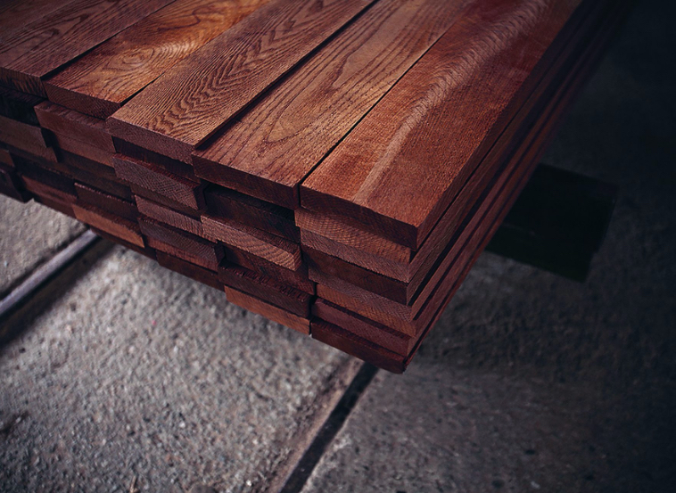 Stack of thermally treated wooden boards with a dark, even color and enhanced durability.