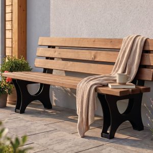 Campo garden bench made of thermally modified pine with a black metal frame on a terrace in front of a house.