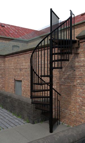 Outdoor spiral staircase Rondo Zink Color in black in front of a brick wall. The galvanized steel staircase with black powder coating features vertical balusters and anti-slip tear plate steps for safe use in outdoor areas.