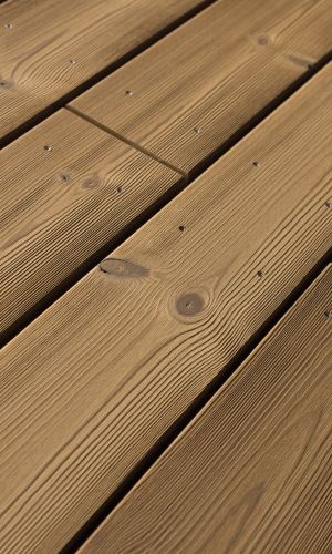 Detailaufnahme der Holzterrassendielen Water-Arum, gebürstet, schräg verlegt. Die natürliche Maserung und die sichtbaren Befestigungsschrauben verleihen der Oberfläche eine hochwertige und robuste Optik.