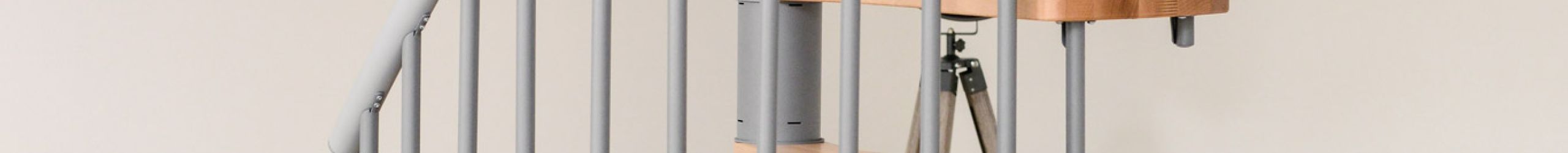 Die Spindeltreppe Metallica Smart mit grauem Metallgestell und hellen Holzstufen passt sich ideal modernen Wohnbereichen an. Kompakte Bauweise für stilvolle Raumlösungen mit wenig Platzbedarf.