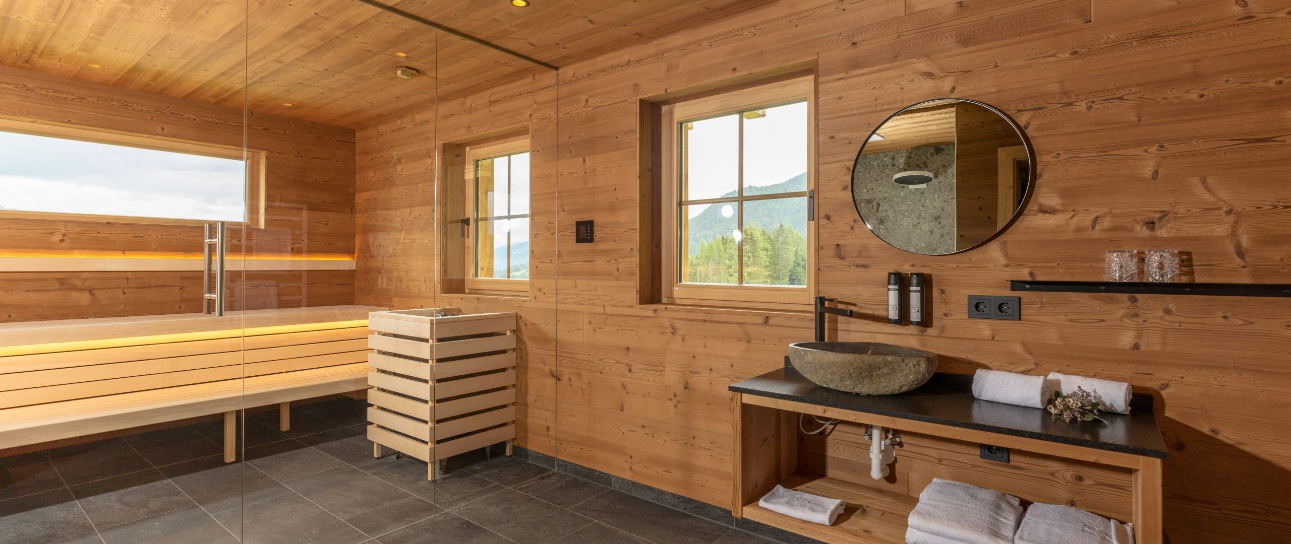 Moderner Wellnessbereich mit Sauna, Waschbecken und Holzverkleidung aus gebürsteter Gladiola von Minka in der Almwelt Schwab-Walcher.