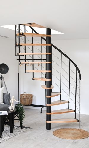 Spindeltreppe Helios in modernem Wohnraum. Die elegante Kombination aus hellen Holzstufen und schwarzem Metall sorgt für ein stilvolles und platzsparendes Design. Ideal für offene Wohnkonzepte.