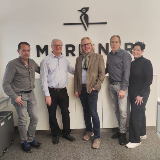 Von links nach rechts: Gerhard Bradatsch (Betriebsleitung), Ernst Janner (Geschäftsführer), Rupert Plewa (Verkaufsleiter Innen), Martin Breitenberger (Verkaufsleiter Außen) und Martina Dunst (Leiterin Buchhaltung). Alle stehen nebeneinander, schauen in die Kamera und lächeln. Das Bild wurde anlässlich der Übernahme von Mareiner Holz durch Minka aufgenommen.