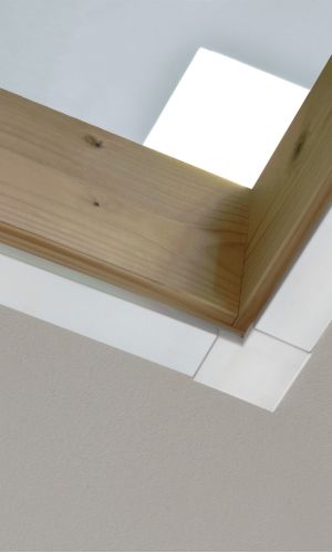 Nahaufnahme einer Holz-Zarge mit einer weißen Verkleidungsleiste vom Typ „Minka Fix“ mit 27 mm Breite, montiert an der Decke eines Innenraums.
