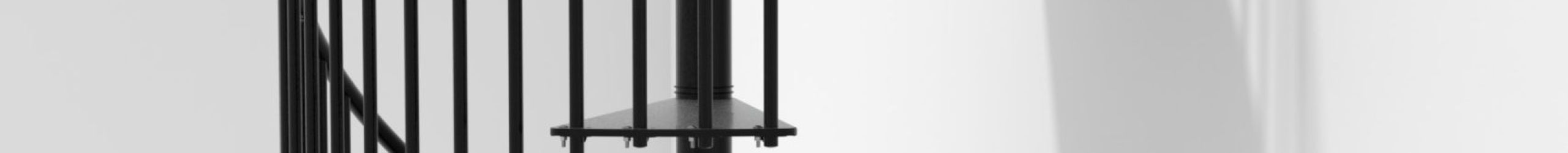 Spindeltreppe Portofino aus schwarzem Metall mit senkrechten Geländerstäben und einem Handlauf aus PVC, montiert in einem weißen, modernen Innenraum. Die Treppe führt elegant in einer Spirale nach oben.