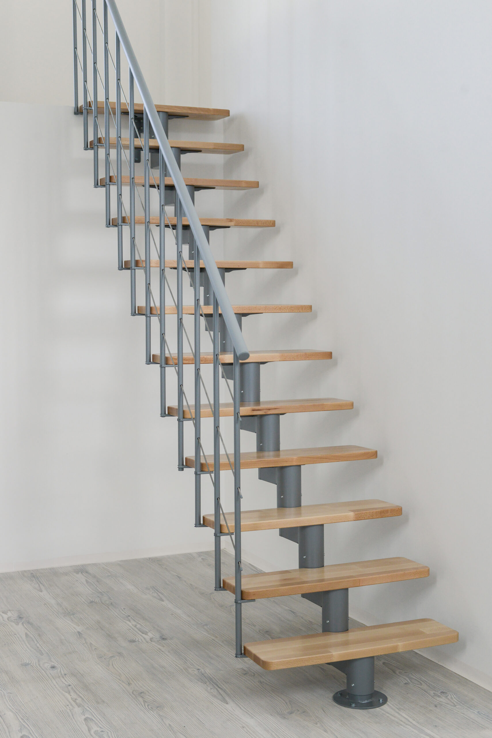 Frontalansicht der Comfort Top Treppe mit grauer Metall-Mittelholmkonstruktion und Stufen aus Buchenholz.