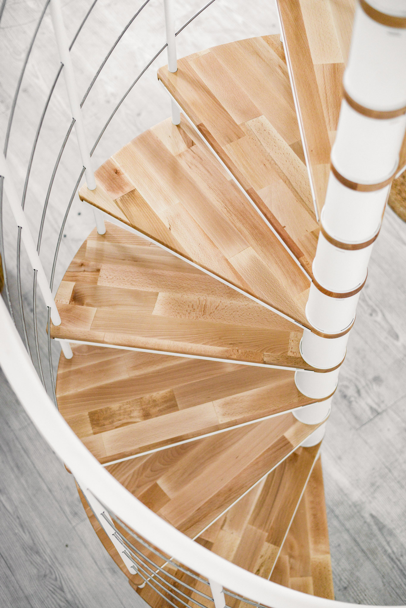 Detailaufnahme der Spindeltreppe Fusion, Ansicht von schräg oben auf die Buchenstufen.