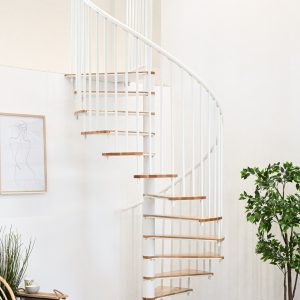 Spindeltreppe Switch mit Buchenstufen und weißem Metallgeländer eingebaut in einem hellen Raum mit Pfanzen, Stuhl und Beistelltisch