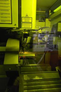 Blick ins innere der Laseranlage: Ein Rohr wird geschnitten und es sprühen Funken