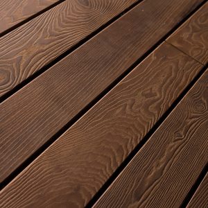 Detailaufnahme der Holzterrassendielen Lotus, gebürstet, schräg verlegt. Die dunkle Maserung und feine Struktur unterstreichen die edle Optik des Minka Wood Lotus-Holzes.