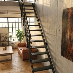 Schwarze Metalltreppe mit Geländer an Betonwand in modernem Loft mit Holzboden und großer Fensterfront.