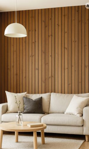 Modernes Wohnzimmer mit gebürsteten Arum Wandpaneelen in warmer Holzoptik als vertikale Akzentwand hinter einem hellen Sofa. Die hochwertige Holzverkleidung verleiht dem Raum eine natürliche Ausstrahlung, elegante Struktur und zeitlose Wohnatmosphäre.